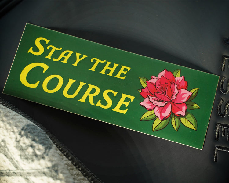 Motivational sticker with 'Stay the Course' and a flower on a dark background