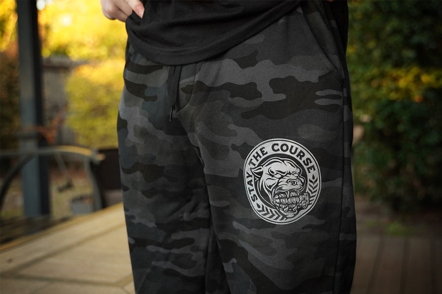 Camouflage pants with a logo on a blurred outdoor background