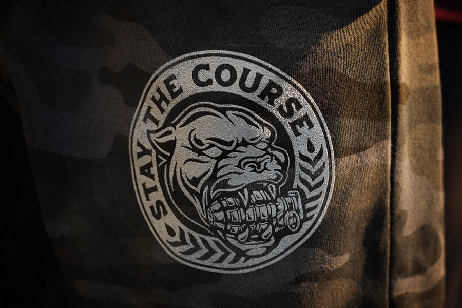 Black Camouflage fleece pants with a graphic of a panther and 'Stay the Course' text on a dark background