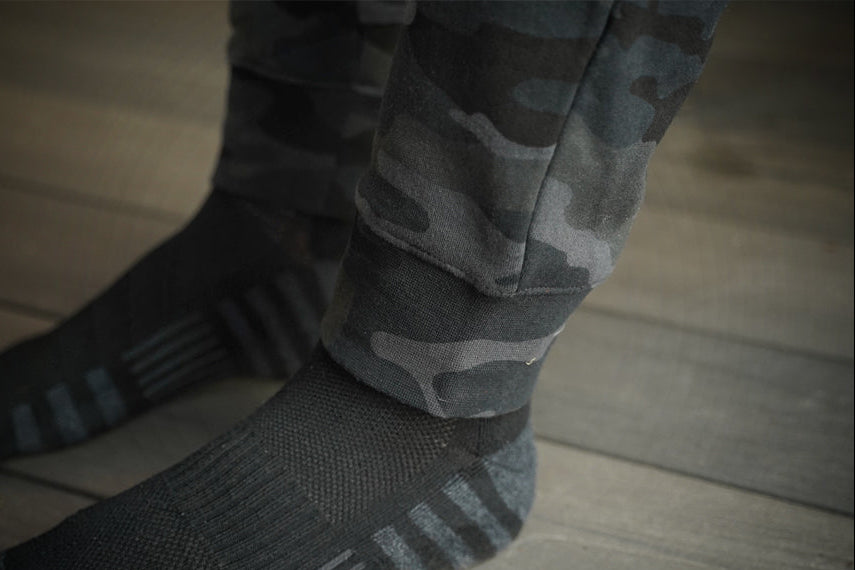 Camouflage pants cuff on a wooden floor