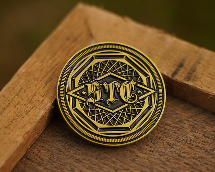 Antique brass coin with intricate design on a wooden surface