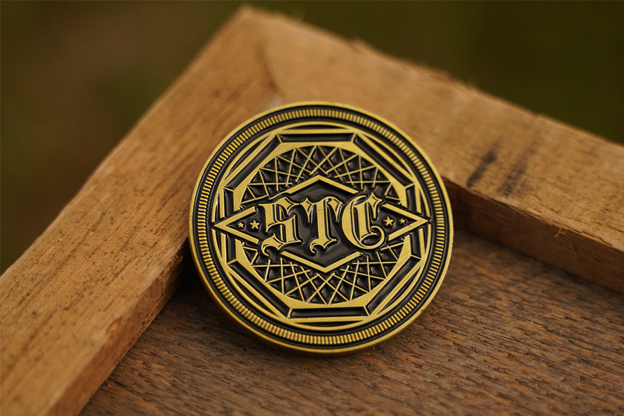 Antique brass coin with intricate design on a wooden surface