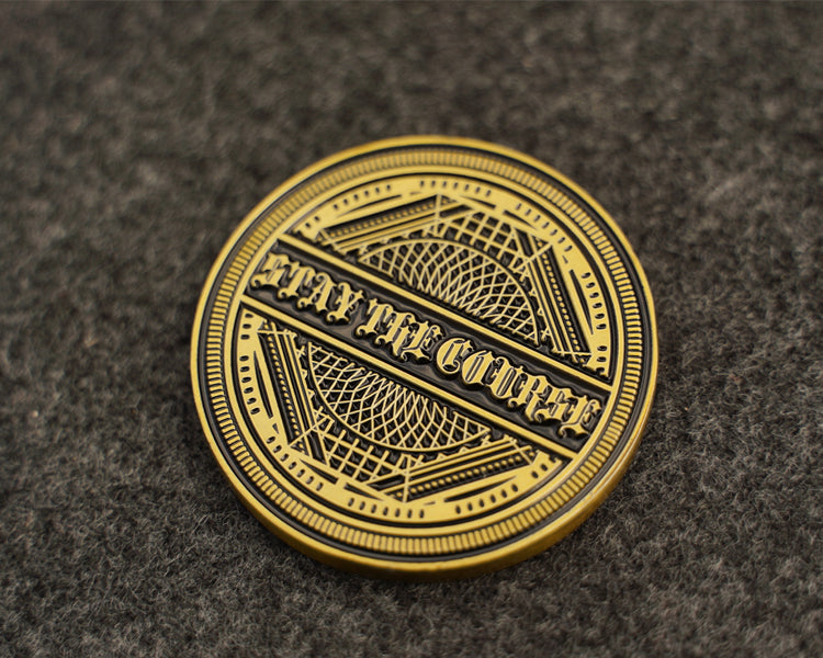 Antique brass coin with 'Stay the Course' text on a textured brown background