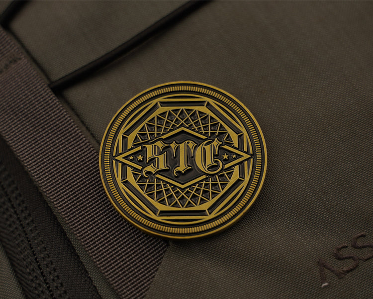 Close-up of antique brass emblem on a brown fabric surface