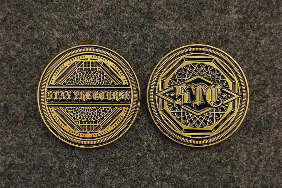 Two antique brass coins with intricate designs and text on a dark textured background