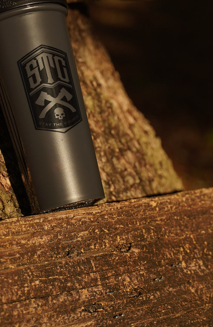 Black shaker bottle with a STC logo on a wooden surface