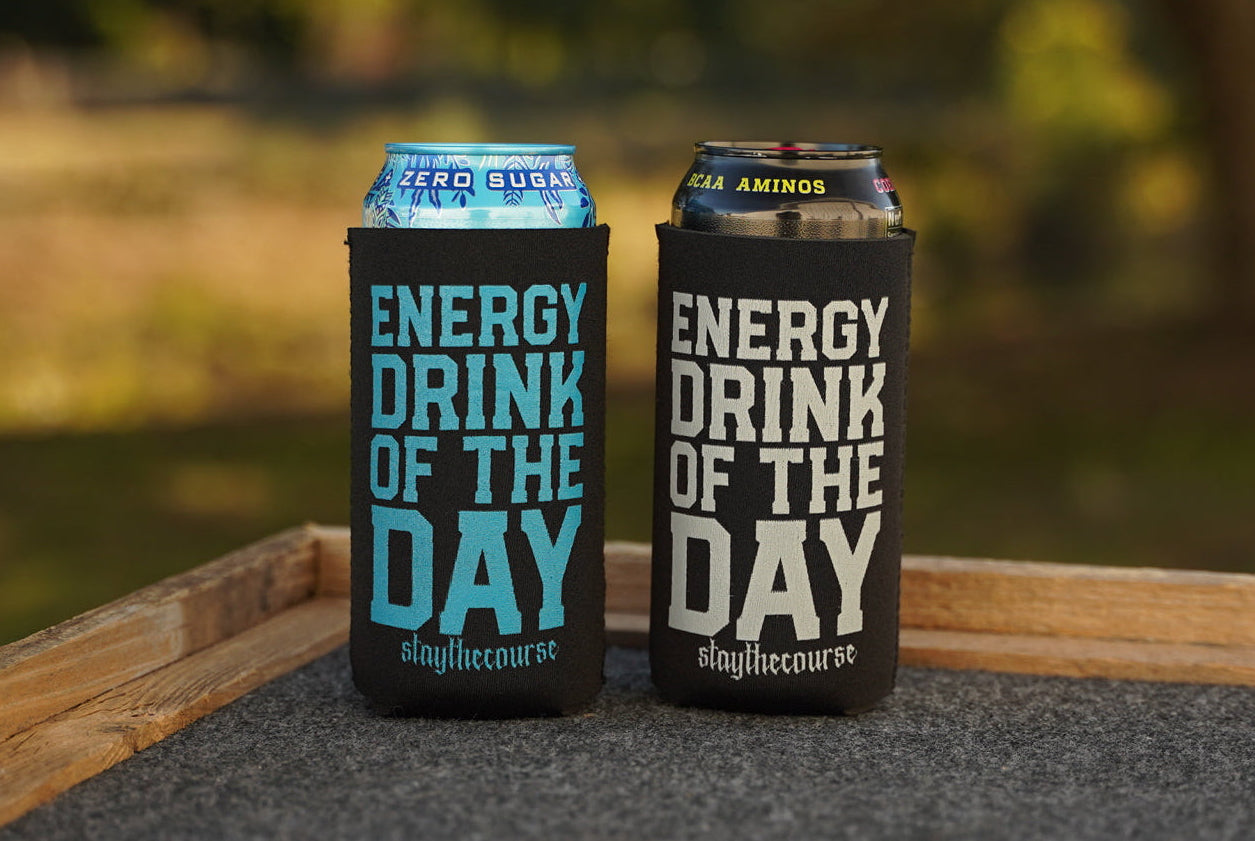 Two energy drink cans with 'Energy Drink of the Day' labels on a wooden surface.