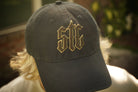 Black cap with gold and brown embroidery on a blurred background