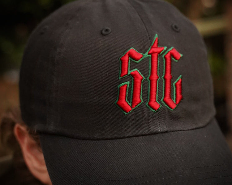 Black cap with red and green logo on a blurred background