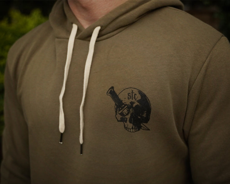 Military green hoodie with a black graphic design on the chest against a dark background