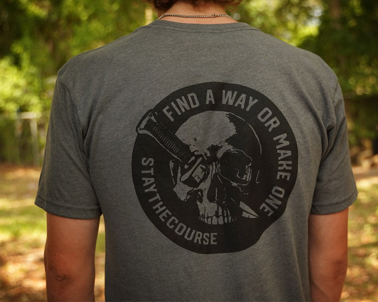 Person wearing a gray shirt with black graphic print that says "Find a way or make one - Stay the Course"