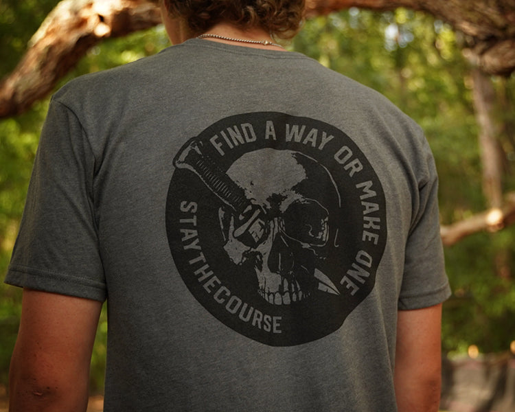 Person wearing a gray shirt with black graphic print that says "Find a way or make one - Stay the Course"