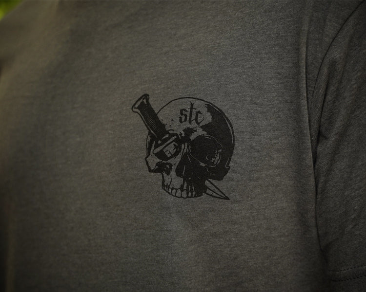 Person wearing a gray shirt with black graphic of a skull and dagger