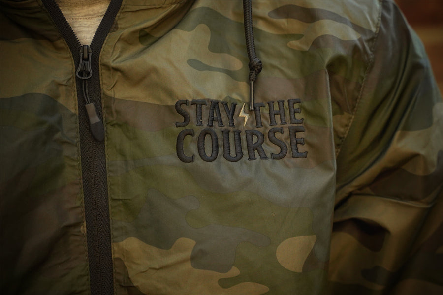 Camouflage jacket with 'Stay The Course' text on a forest camo background