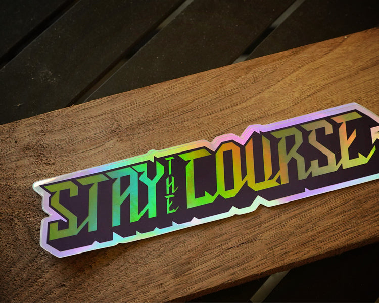 Holographic 'Stay the Course' sticker on a wooden surface