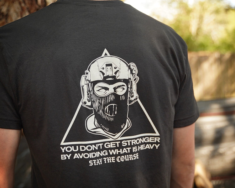 Person wearing a black t-shirt with a graphic design on the back, featuring text and a stylized figure.