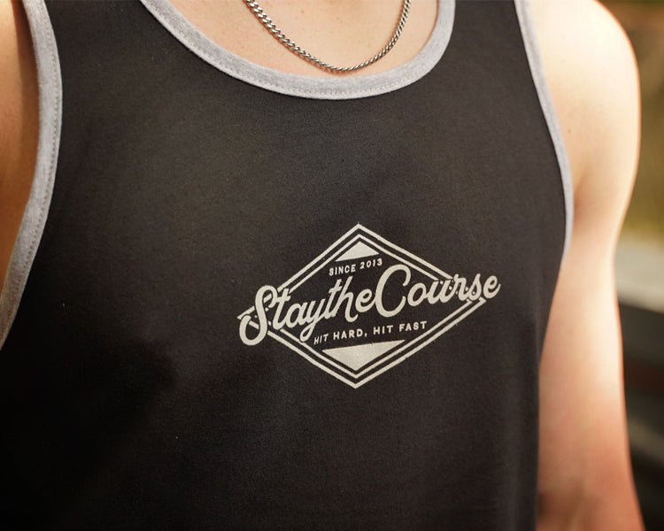 Person wearing a black tank top with 'Stay the Course' logo.
