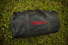 black camo duffle bag with red embroidery in grass