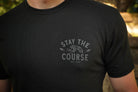 Black t-shirt with 'Stay the Course' text and graphic on a blurred background