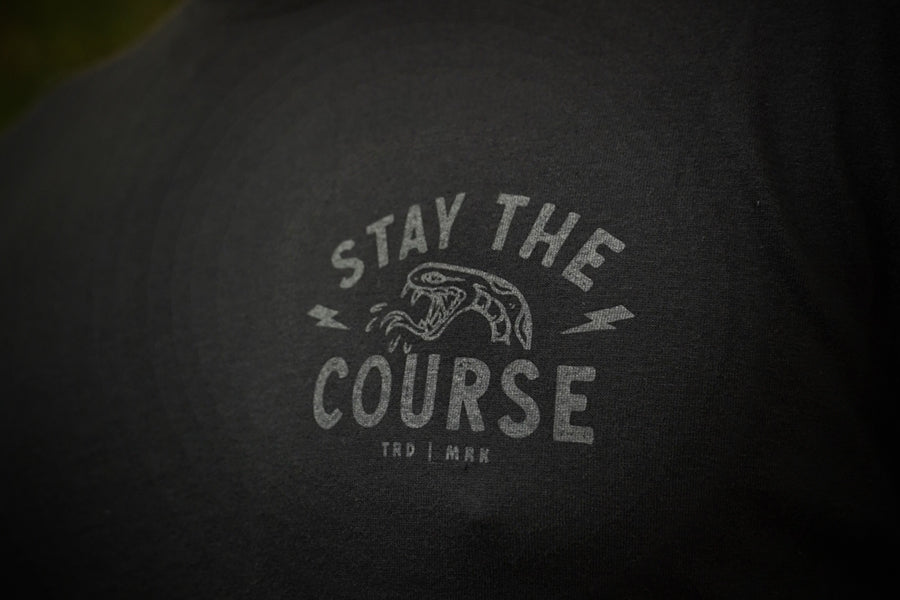 Text 'Stay the Course' on a black t-shirt