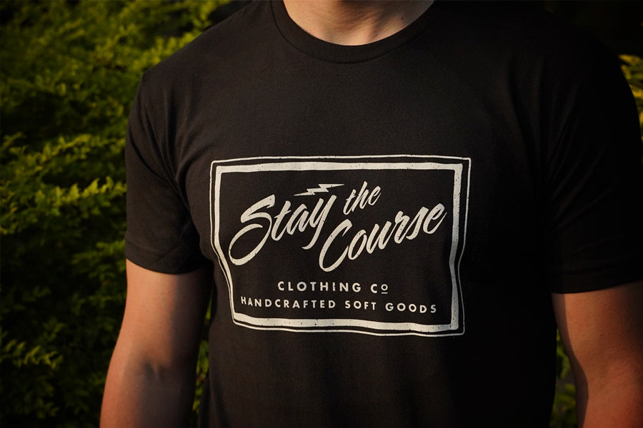 Person wearing a black t-shirt with 'Stay the Course Clothing Co' logo.