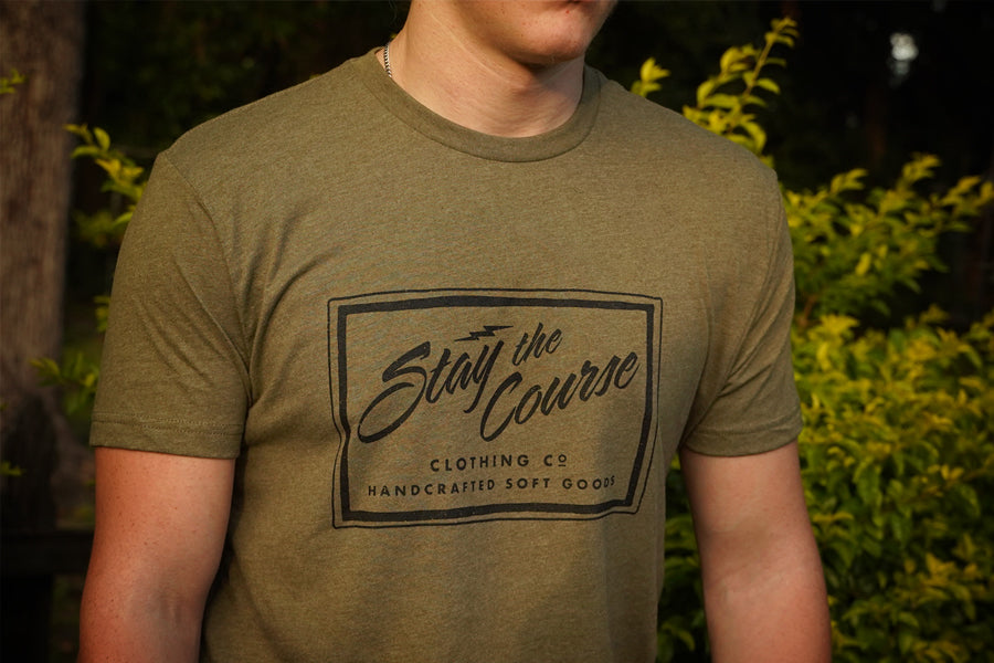 Person wearing a green t-shirt with 'Stay the Course Clothing Co' logo.
