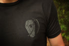Black t-shirt with a gray graphic design on a person wearing it.