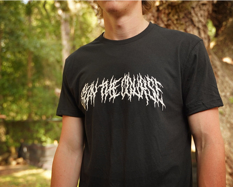 Person wearing a black T-shirt with "Stay the Course" printed in white in heavy metal style
