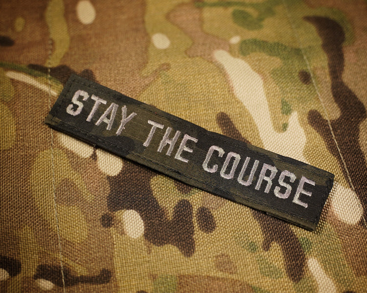 Black camouflage patch reading 'STAY THE COURSE'