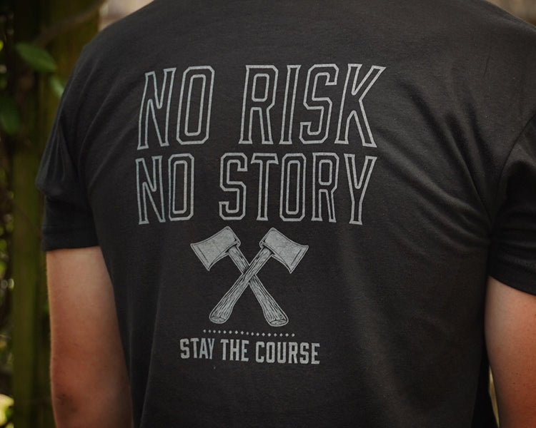 Person wearing a black t-shirt with 'No Risk No Story, Stay the Course' text and graphic on the back.