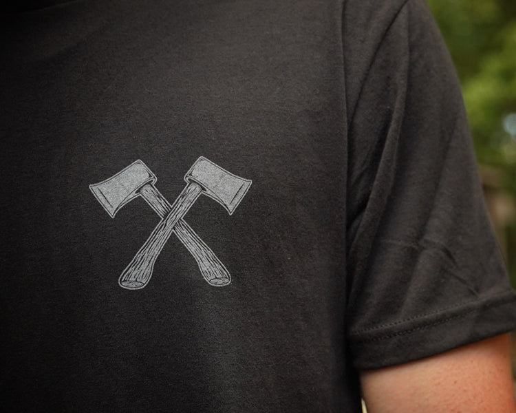 Black t-shirt with crossed axes design on the back, blurred background