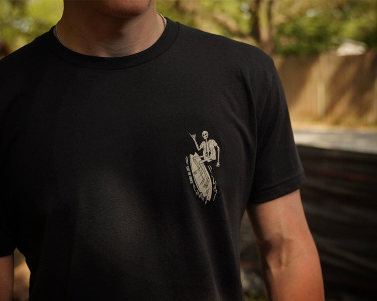 Person wearing a black t-shirt with an off white graphic design outdoors