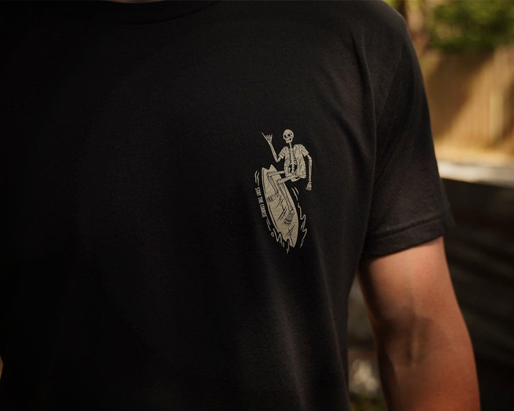 Black t-shirt with a white graphic on the back, worn by a person.