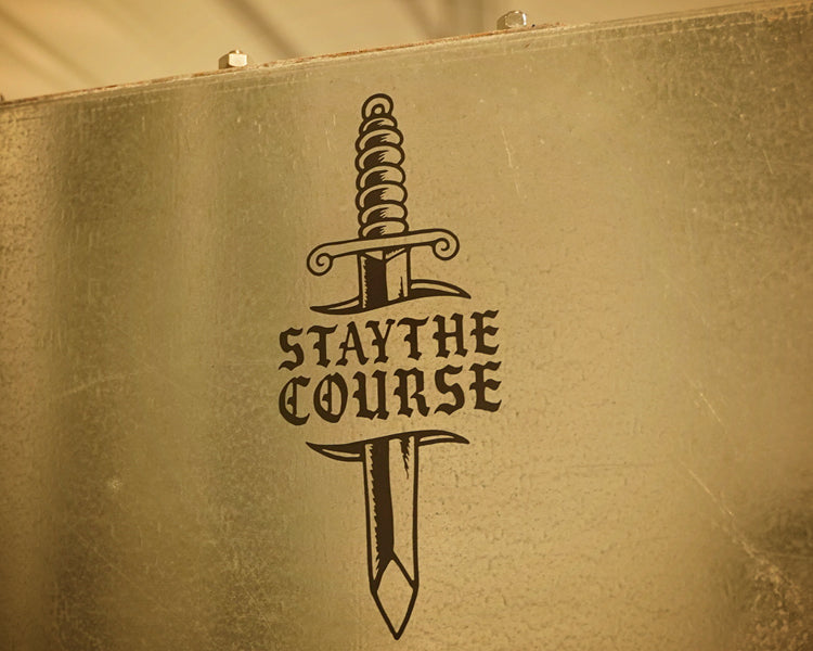 White vinyl decal of dagger and "stay the course" on metal cabinet