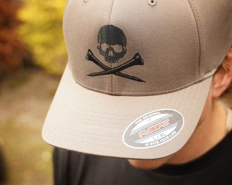 Gray cap with skull and golf tees design worn by a person outdoors