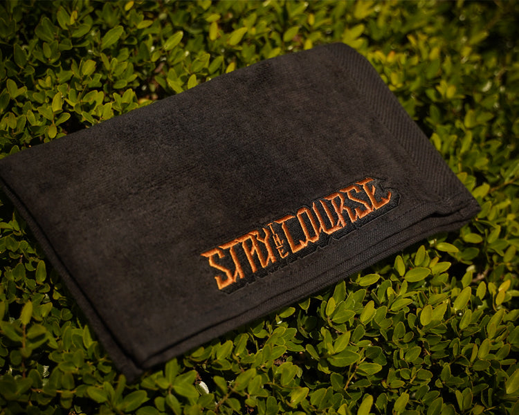 Black towel with 'Stay the Course' text on grass