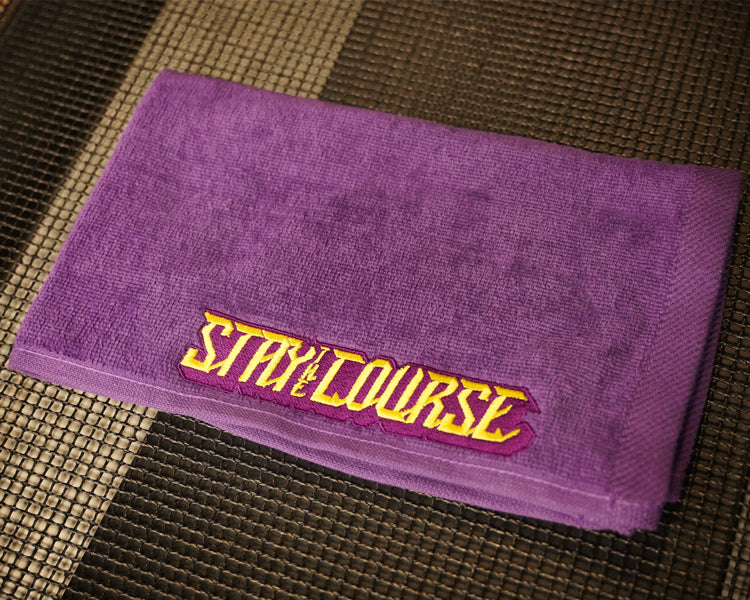 Purple hand towel with yellow embroidered "Stay the Course"