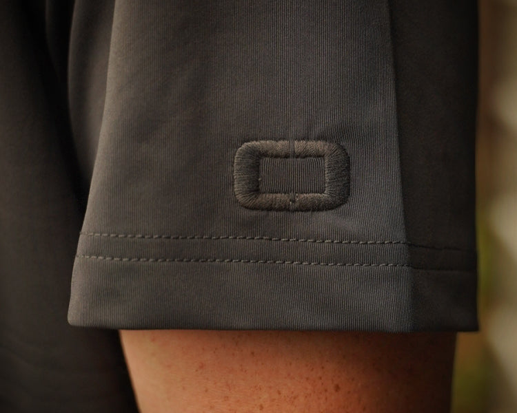 Close-up of a dark gray fabric with a logo on a blurred background