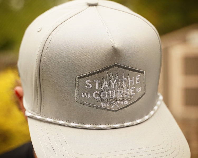 Gray cap with 'Stay the Course' logo on a blurred background