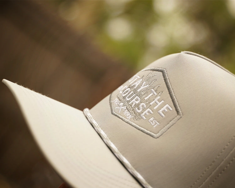 gray cap with a logo on a blurred natural background