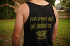 Person wearing a black tank top with green text and logo outdoors