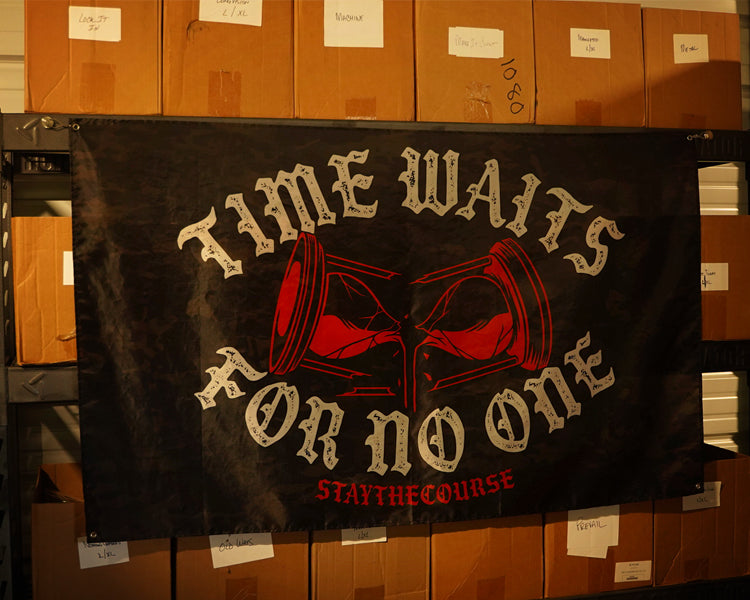 5x3 black camo flag with white and red design that says ice waits for no one, hanging in a warehouse.