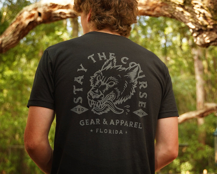 Person wearing a black t-shirt with gray print of wolfhound head and "stay the Course"