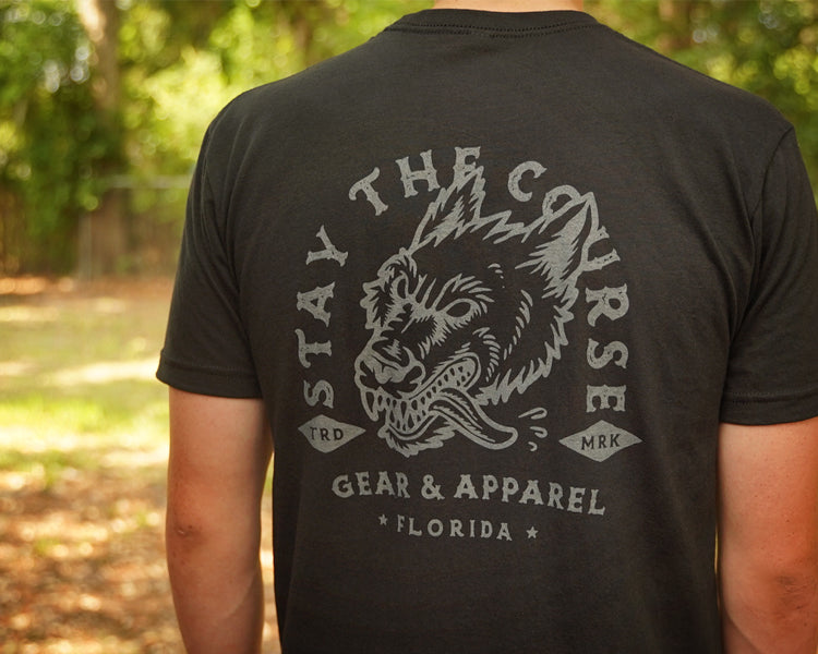 Person wearing a black t-shirt with gray print of wolfhound head and "stay the Course"