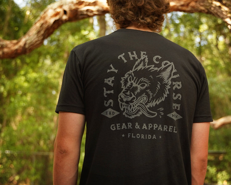 Person wearing a black t-shirt with gray print of wolfhound head and "stay the Course"