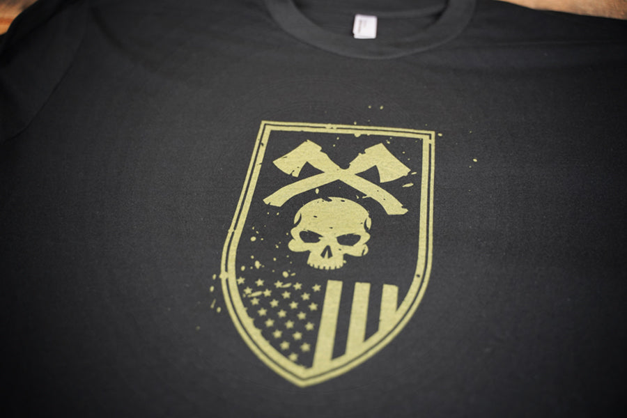Skull and axe graphic in green on black t-shirt
