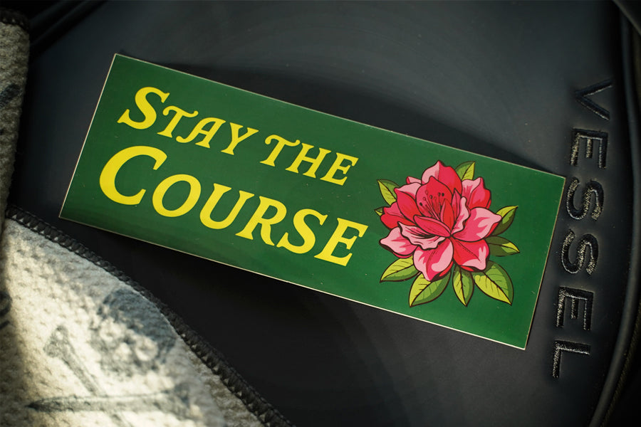 Motivational sticker with 'Stay the Course' and a flower on a dark background
