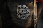 Camouflage pants with a logo featuring a panther and text 'Stay The Course'.