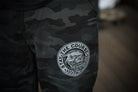 Camouflage pants with a gray logo on a blurred background