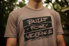Person wearing a t-shirt with 'Built for Violence' text design.